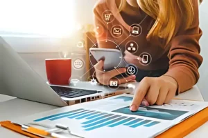 Businesswoman analyzing marketing metrics on a digital tablet and printed reports, illustrating effective strategies for tracking the success of landscaping marketing campaigns.