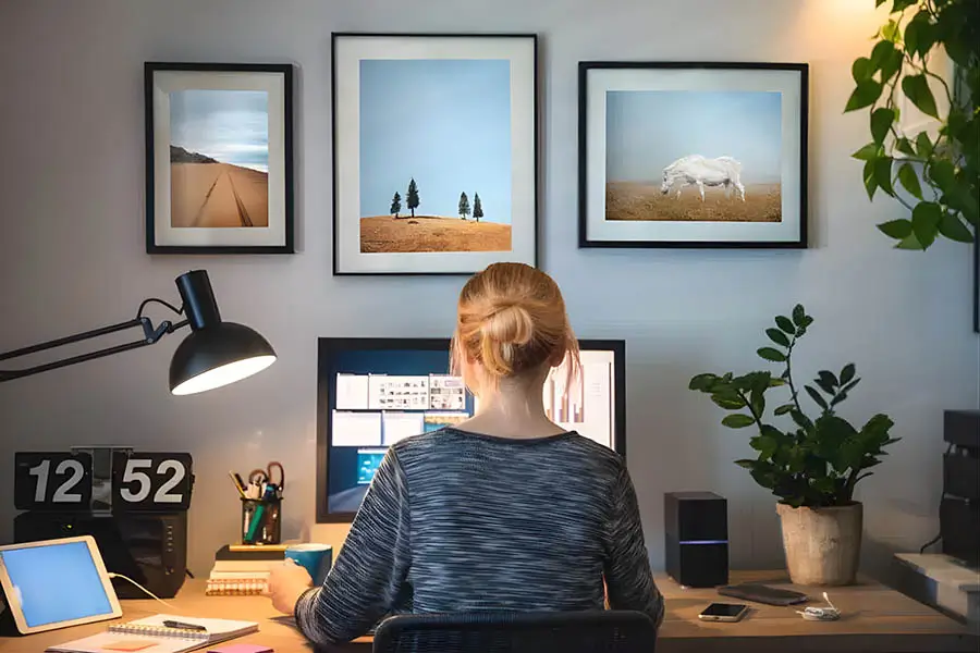 Social media manager creating content to promote lawn sprinkler installation, working at a desk with computer and marketing tools